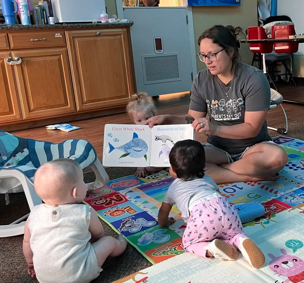 A Highland PDO teacher reading with babies during classroom time